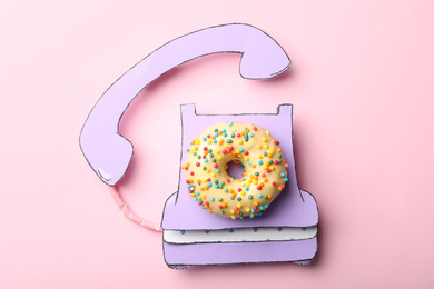 Vintage phone made with donut on pink background, top view