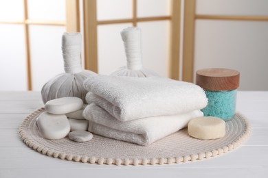 Photo of Spa composition with care products on white wooden table in room