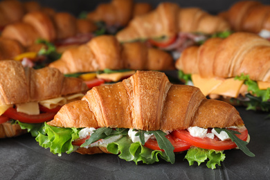 Bunch of tasty croissant sandwiches on grey table
