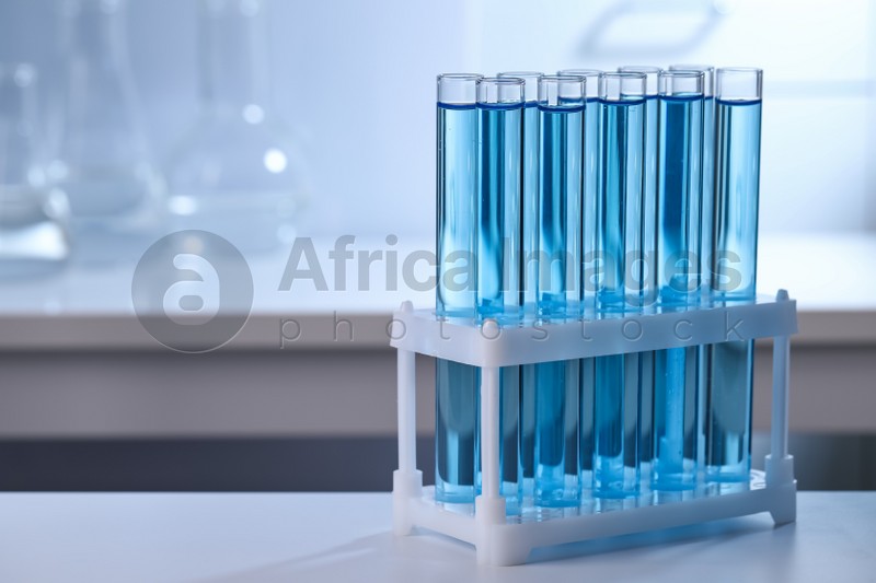 Test tubes with reagents on table in laboratory, space for text