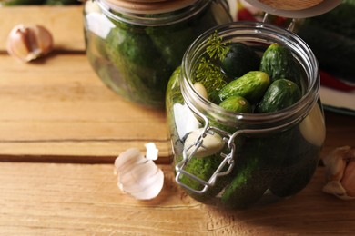 Jar with cucumbers, garlic and dill on wooden table, space for text. Pickling recipe