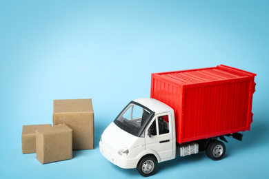 Toy truck with boxes on blue background, space for text. Logistics and wholesale concept