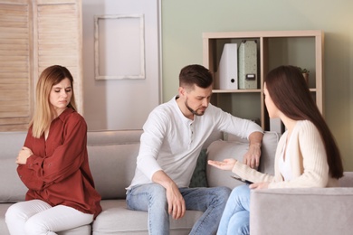 Family psychologist working with young couple in office