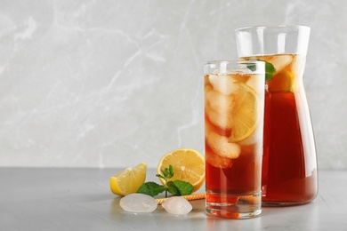 Refreshing iced tea on grey table against light background. Space for text