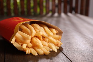 MYKOLAIV, UKRAINE - AUGUST 12, 2021: Big portion of McDonald's French fries on wooden table, closeup