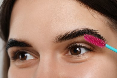 Photo of Brushing woman's eyebrows after tinting, closeup view