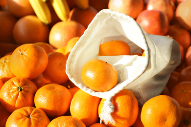 Cotton eco bag with fruits on tangerines, closeup. Life without plastic