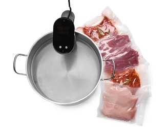 Thermal immersion circulator in pot and meat on white background, top view. Vacuum packing for sous vide cooking