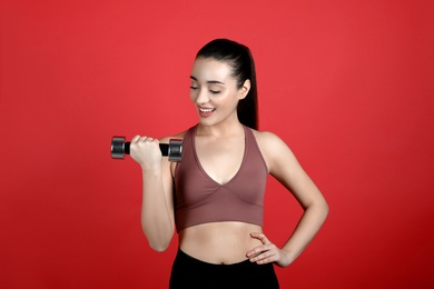 Woman with dumbbell as girl power symbol on red background. 8 March concept