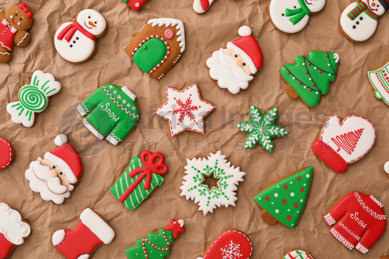 Different Christmas gingerbread cookies on crumpled parchment, flat lay