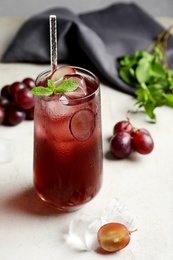 Delicious grape soda water with mint on white table. Refreshing drink