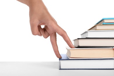 Photo of Woman imitating stepping up on books with her fingers against white background, closeup