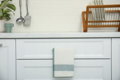 Clean towel hanging on drawer handle in kitchen