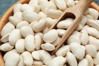 Bowl and scoop with uncooked white beans, closeup