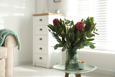 Photo of Vase with bouquet of beautiful Protea flowers on table at home