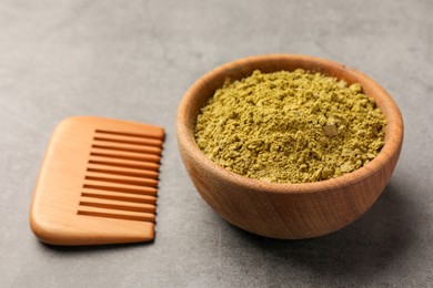 Photo of Henna powder and comb on light grey background, closeup. Natural hair coloring