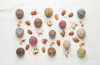 Delicious vegan candy balls and nuts on white table, flat lay