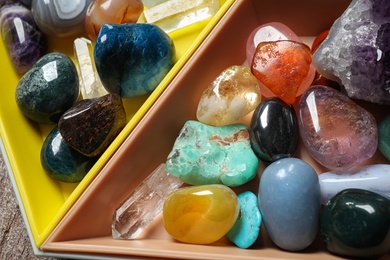 Photo of Plastic tray with different beautiful gemstones on table