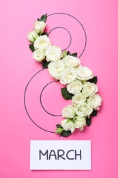 Photo of 8 March greeting card design with white roses on pink background, flat lay. International Women's day