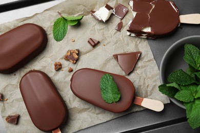 Glazed ice cream bars, fresh mint and chocolate on baking tray, flat lay
