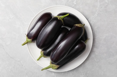 Raw ripe eggplants on grey table, top view