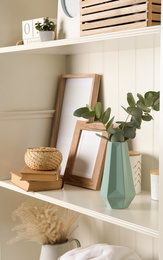 Photo of White shelving unit with different decorative elements