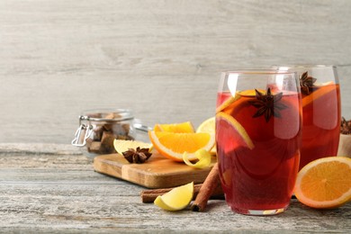 Aromatic punch drink and ingredients on wooden table. Space for text