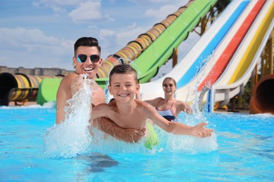 Happy family playing in swimming pool at water park