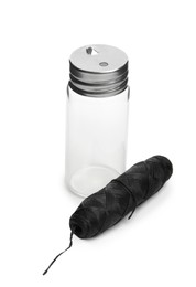 Roll of natural dental floss and jar on white background