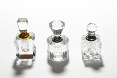 Different elegant perfume bottles on white background