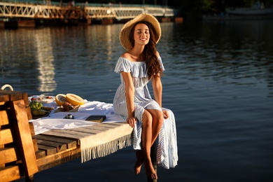 Young woman spending time on pier at picnic