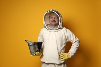 Photo of Beekeeper in uniform with smokepot on yellow background