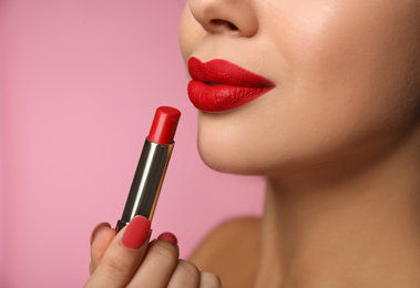 Woman with red lipstick on pink background, closeup