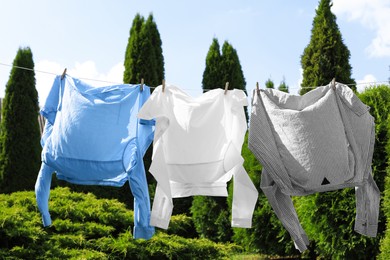 Clean clothes hanging on washing line in garden. Drying laundry