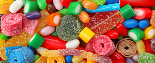 Delicious colorful chewing candies as background, top view. Banner design 