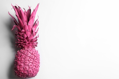 Photo of Painted pink pineapple on white background, top view. Creative concept