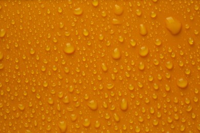 Photo of Many water drops on bright orange background