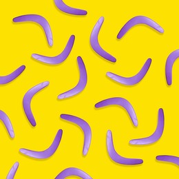 Violet boomerangs on yellow background, flat lay