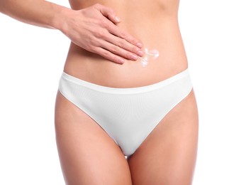 Photo of Woman applying body cream onto her belly against white background, closeup