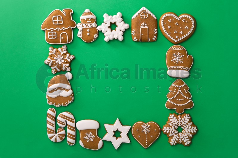 Frame made with different Christmas gingerbread cookies on green background, top view. Space for text