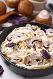 Photo of Delicious pasta with mushrooms in pan on table, closeup