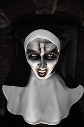 Portrait of scary devilish nun outdoors. Halloween party look