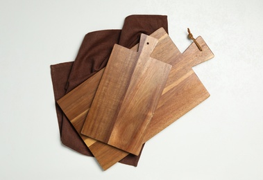 Wooden boards and napkin on white background, top view. Cooking utensils
