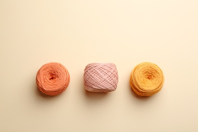 Clews of knitting threads on color background, flat lay. Sewing stuff