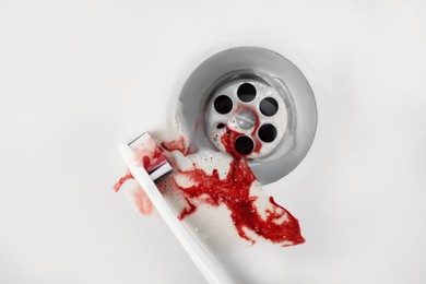 Toothbrush with paste and blood in sink, top view. Gum inflammation