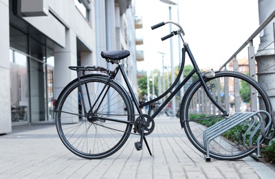 Modern black bicycle parked on city street