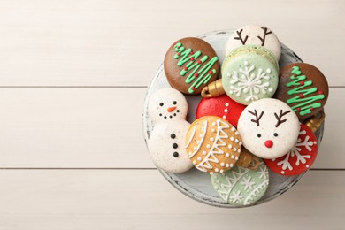 Beautifully decorated Christmas macarons on white wooden table, top view. Space for text