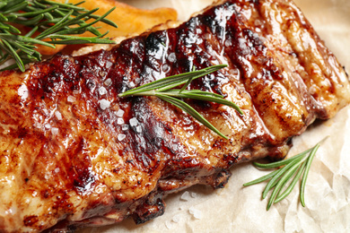 Photo of Delicious grilled ribs with rosemary, closeup view