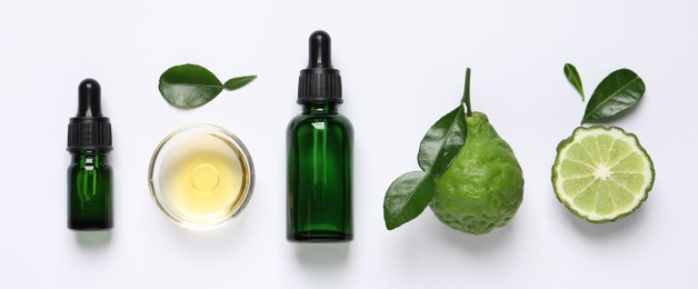 Bergamot essential oil and fresh fruits on white background, flat lay