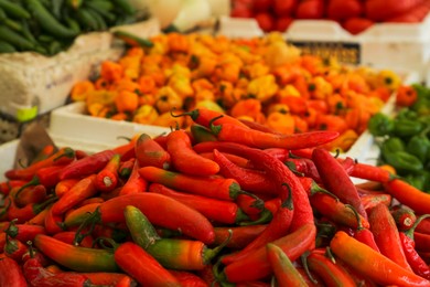 Heap of fresh Serrano peppers on counter at market, closeup. Space for text